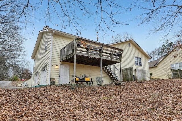 back of house with a wooden deck and a garage