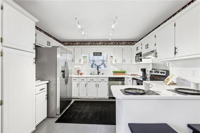 kitchen featuring stainless steel appliances, sink, white cabinets, and kitchen peninsula