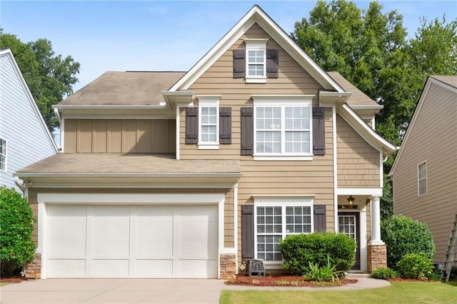 view of front of house featuring a garage, concrete driveway, stone siding, a front lawn, and board and batten siding