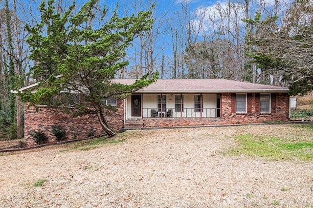 ranch-style house with brick siding, covered porch, and driveway