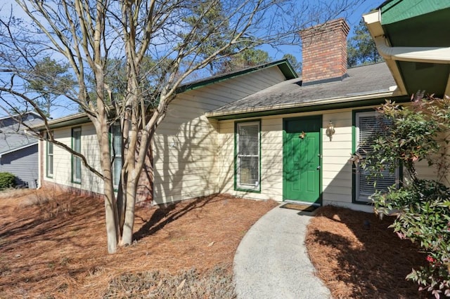 view of exterior entry featuring a chimney