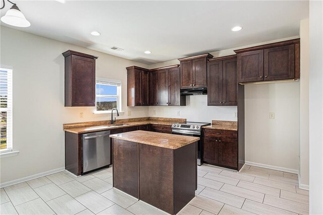 kitchen featuring hanging light fixtures, sink, a kitchen island, dark brown cabinets, and appliances with stainless steel finishes