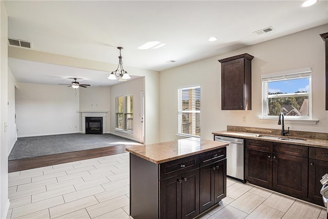 kitchen with a kitchen island, dark brown cabinetry, sink, ceiling fan with notable chandelier, and dishwasher