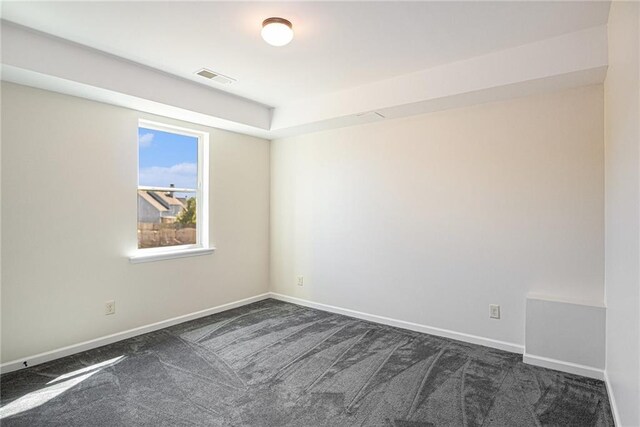 empty room featuring dark carpet