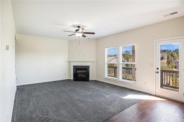 unfurnished living room featuring ceiling fan and dark hardwood / wood-style flooring