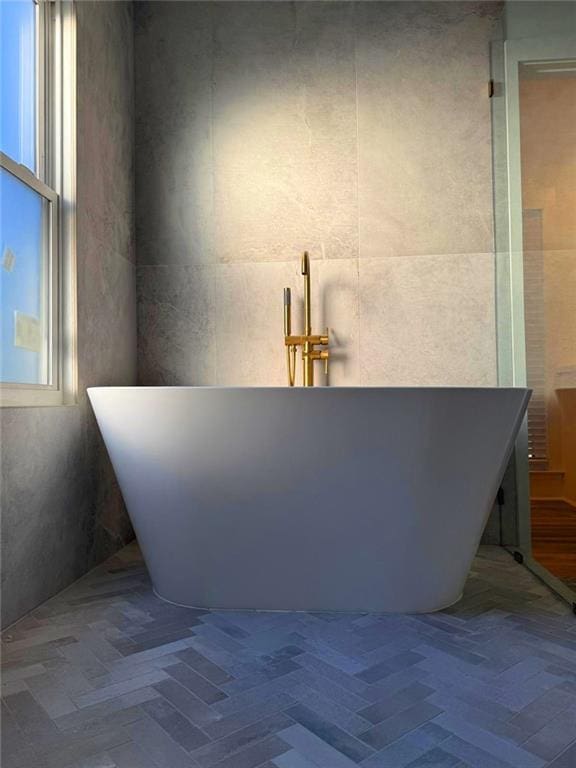 bathroom with a wealth of natural light and a bathtub