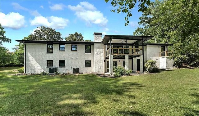 back of property with central AC unit, ceiling fan, and a yard