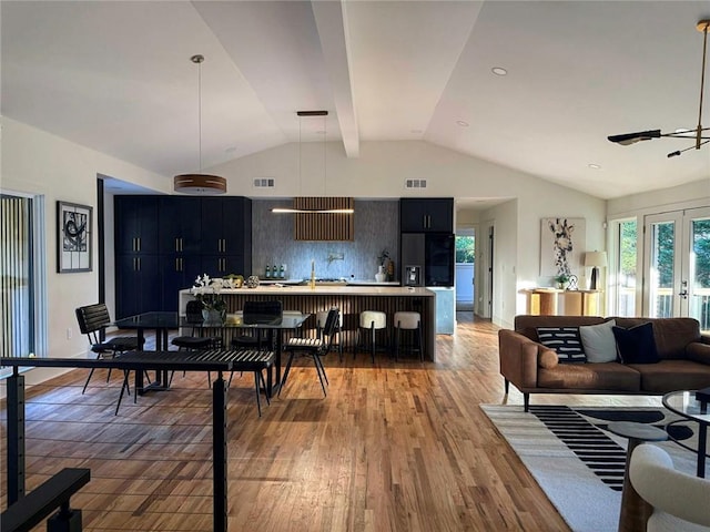 kitchen with ceiling fan, decorative light fixtures, backsplash, a kitchen bar, and hardwood / wood-style flooring