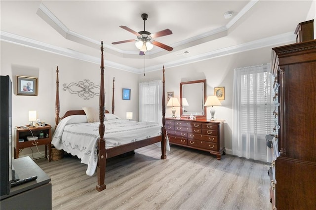 bedroom featuring ornamental molding, a raised ceiling, ceiling fan, and light wood-type flooring