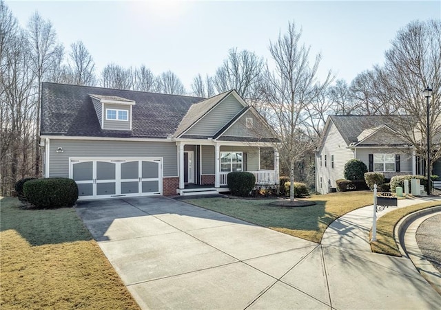 view of front of property featuring a garage, a front lawn, and a porch