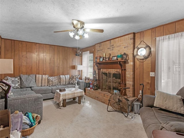 living room with a brick fireplace, wood walls, carpet floors, and a textured ceiling