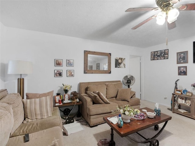 carpeted living room featuring ceiling fan and a textured ceiling