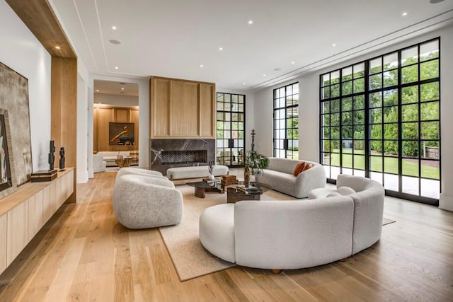 living room featuring a high end fireplace and light hardwood / wood-style floors