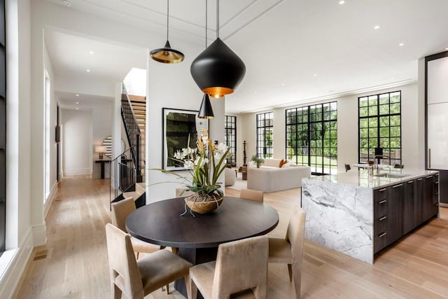 dining area featuring a wall of windows, sink, and light hardwood / wood-style floors