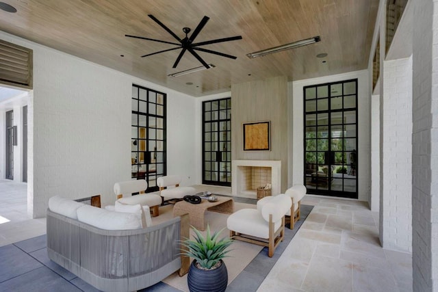 view of patio / terrace with an outdoor living space with a fireplace and ceiling fan