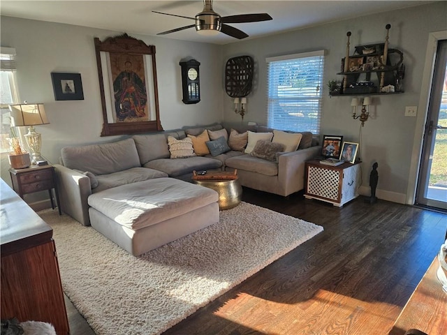 living room with dark wood-style floors, ceiling fan, and baseboards