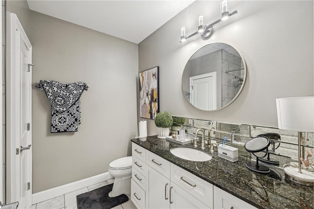 bathroom with vanity, toilet, and tasteful backsplash