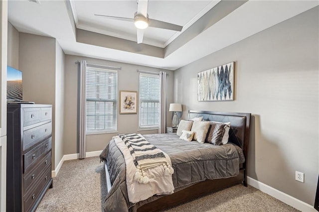 carpeted bedroom featuring a tray ceiling, ceiling fan, and crown molding