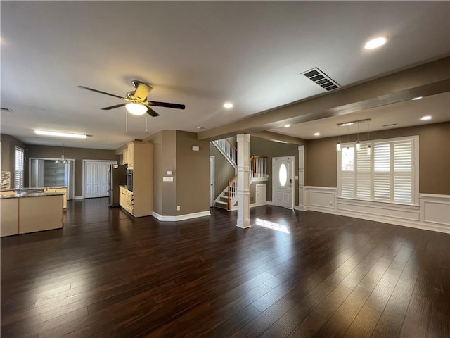 unfurnished living room featuring visible vents, dark wood finished floors, stairway, and ceiling fan