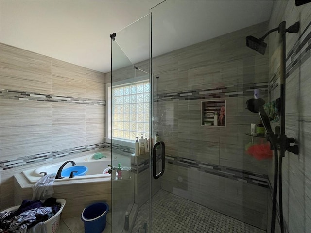 bathroom featuring shower with separate bathtub, tile patterned floors, and tile walls