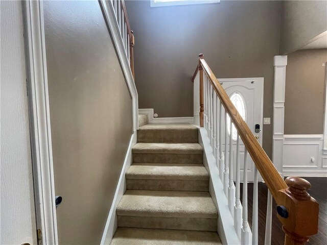 stairs featuring baseboards and a decorative wall