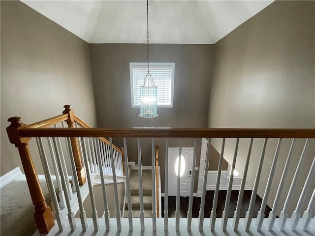 stairs with vaulted ceiling, baseboards, and an inviting chandelier