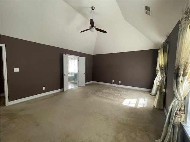 interior space with visible vents, a ceiling fan, light carpet, high vaulted ceiling, and baseboards