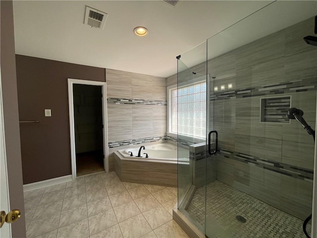 full bathroom featuring visible vents, a stall shower, a bath, baseboards, and tile patterned floors