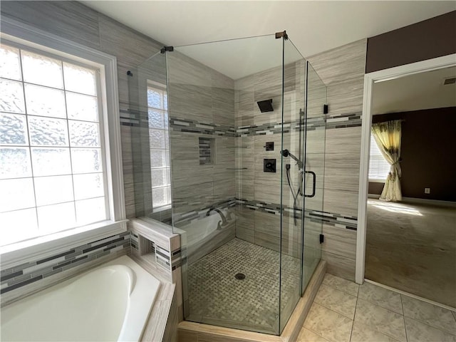 full bath with a stall shower, tile patterned floors, and a bath