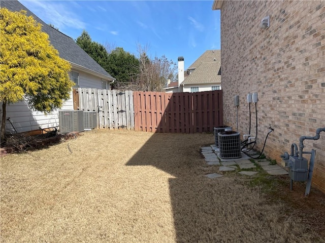 view of yard with central air condition unit and a fenced backyard