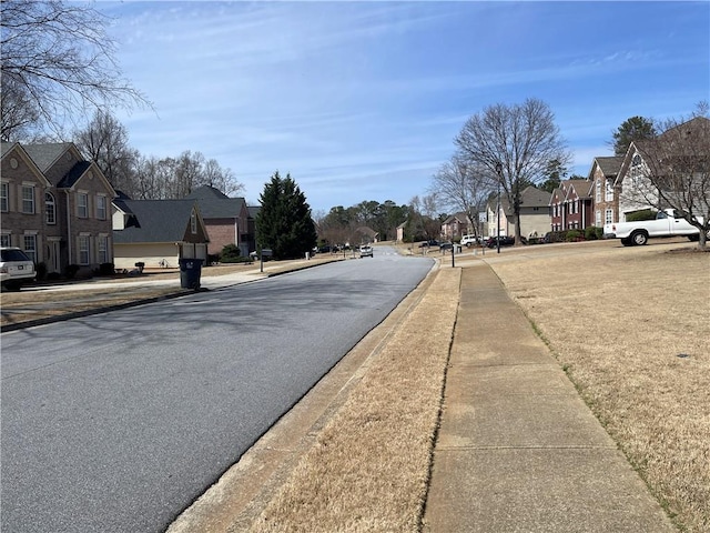 view of street featuring a residential view, curbs, and sidewalks