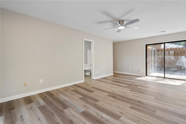 unfurnished room featuring baseboards, visible vents, ceiling fan, and wood finished floors