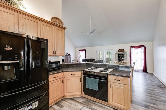 144 Bobs Dr SW, Mableton, GA 30126 - kitchen with light brown cabinets, a peninsula, electric stove, dark countertops, and black fridge