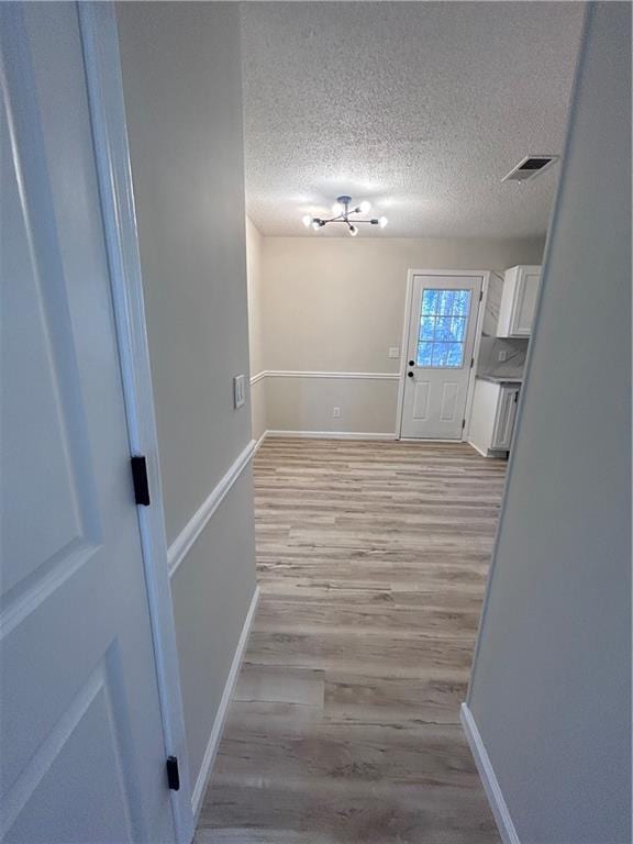 interior space with light wood-type flooring and a textured ceiling