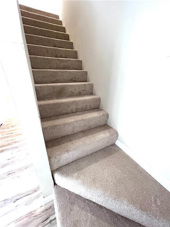 staircase with hardwood / wood-style flooring