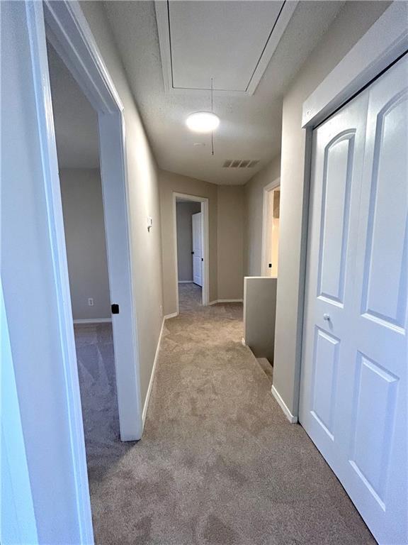 hallway featuring light colored carpet