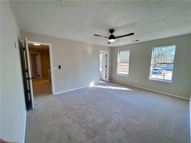 spare room with light carpet, ceiling fan, and a textured ceiling