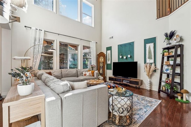 living room with dark hardwood / wood-style floors and a high ceiling