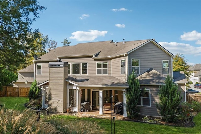 rear view of property featuring a patio area and a lawn