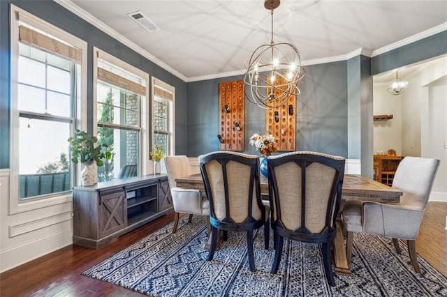 dining room featuring dark wood-type flooring, crown molding, and a notable chandelier