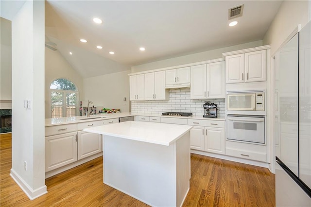 205 Finsbury Park Ct, Suwanee, GA 30024 - kitchen featuring built in appliances, light countertops, decorative backsplash, light wood-type flooring, and recessed lighting