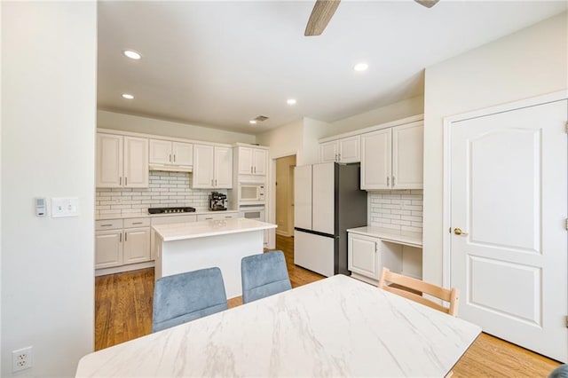 205 Finsbury Park Ct, Suwanee, GA 30024 - kitchen with white appliances, tasteful backsplash, a ceiling fan, light countertops, and a kitchen island