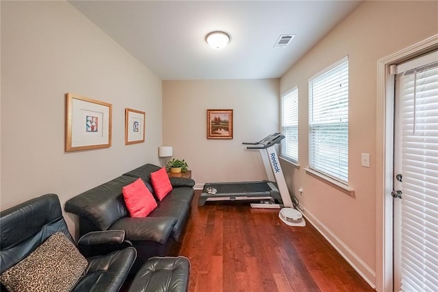 workout room with baseboards, visible vents, and wood finished floors