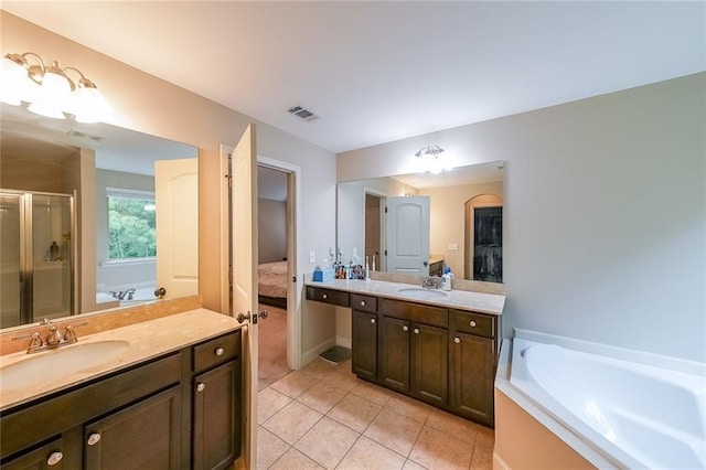 ensuite bathroom featuring visible vents, two vanities, a stall shower, connected bathroom, and a sink