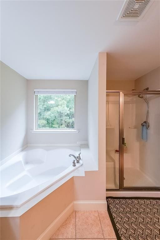 full bath with a garden tub, tile patterned flooring, visible vents, baseboards, and a stall shower