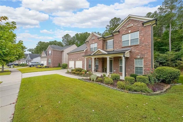 traditional home with a garage, a front yard, brick siding, and driveway