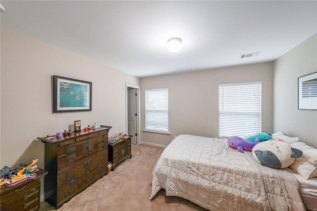 bedroom with light carpet and visible vents