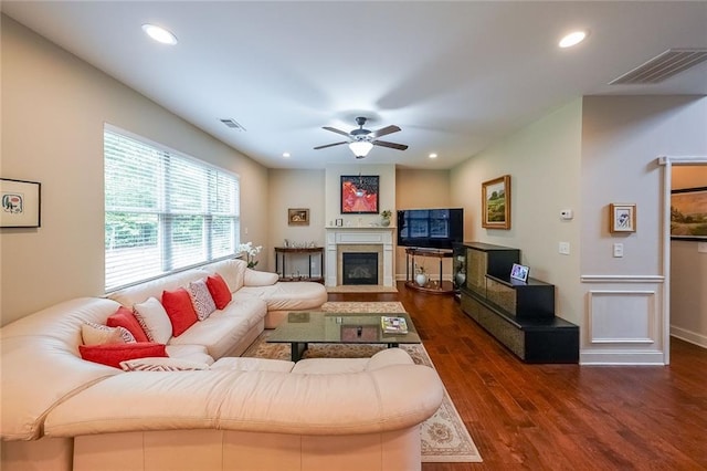 living area with a fireplace with flush hearth, visible vents, wood finished floors, and recessed lighting