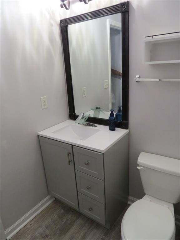 58 Torero Trl, Newnan, GA 30263 - half bathroom featuring vanity, wood finished floors, toilet, and baseboards