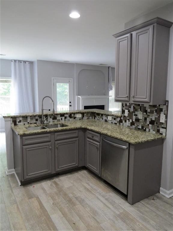 58 Torero Trl, Newnan, GA 30263 - kitchen featuring gray cabinetry, stainless steel dishwasher, a sink, light wood-style flooring, and decorative backsplash
